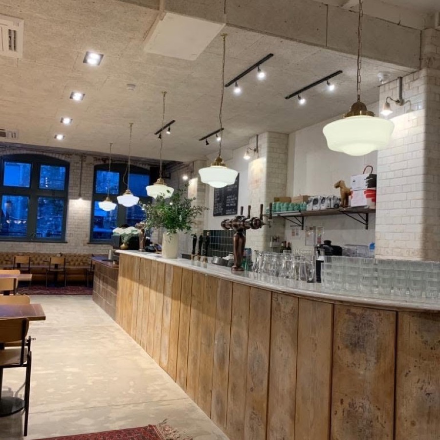 Bar and restaurant interior lit by schoolhouse pendant lights and track spotlights